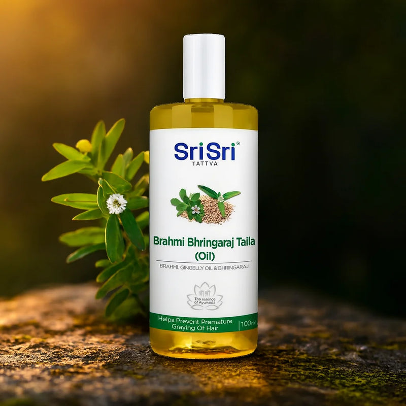 Sri Sri Tattva oil bottle with Bhringraj Plant on a wooden surface