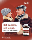 Senior couple dancing, smiling, and looking at each other, with the text "Still dancing, still loving. Keep your heart strong," promoting Arjuna Heart Tonic