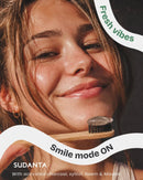 Young woman with toothbrush featuring Sudanta Charcoal Gel toothpaste with charcoal, xylitol, neem and miswak
